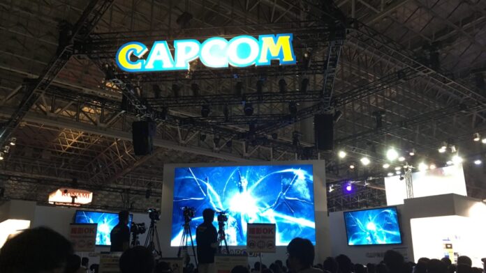 Leuchtender Capcom-Schriftzug über dem Messestand auf der Tokyo Game Show, darunter Bildschirme und Besucher