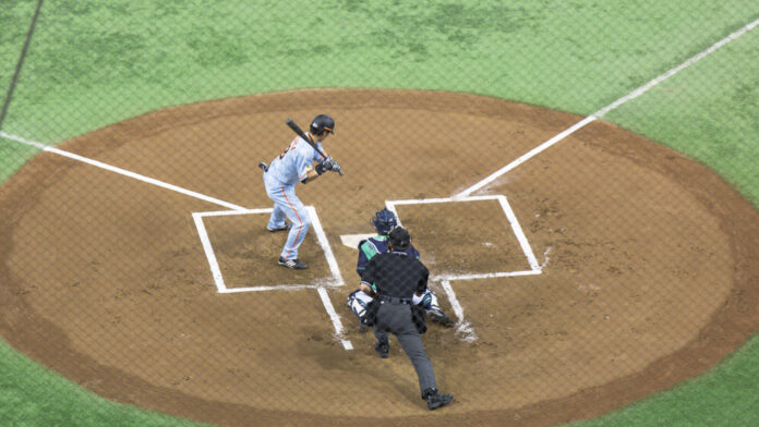 Ein Schlagmann der Yomiuri Giants an der Home Plate im Tokyo Dome, dahinter Catcher und Schiedsrichter