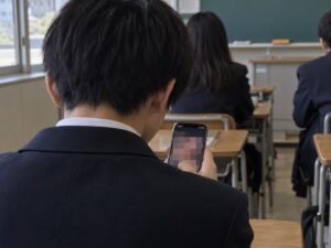 Schüler mit Smartphone in einem japanischen Klassenzimmer