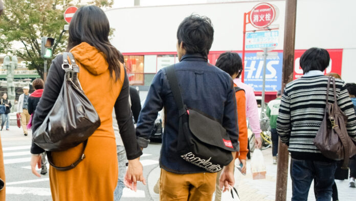 Ein Paar geht Hand in Hand durch Sannomiya in Kobe