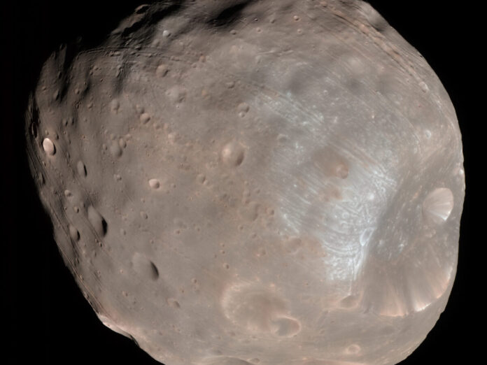 Der Marsmond Phobos, ein unregelmäßig geformter, grauer Himmelskörper mit Kratern, vor schwarzem Hintergrund