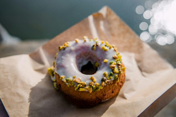 Ein Donut auf einer braunen Papiertüte (Symbolbild)