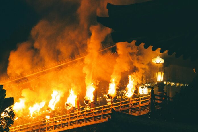 Fackeln an einem hölzernen Tempelgang bei einem Feuerfest in Nara (Symbolbild, nicht das Kebesu-Fest)