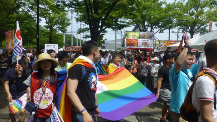 Teilnehmer der Tokyo Rainbow Pride mit Regenbogenflagge in Tokio