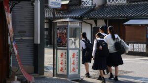 Schülerinnen in Uniform mit Rucksäcken auf einer Straße in Kurashiki
