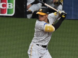 Teruaki Satō von den Hanshin Tigers im Nadelstreifentrikot am Schlag